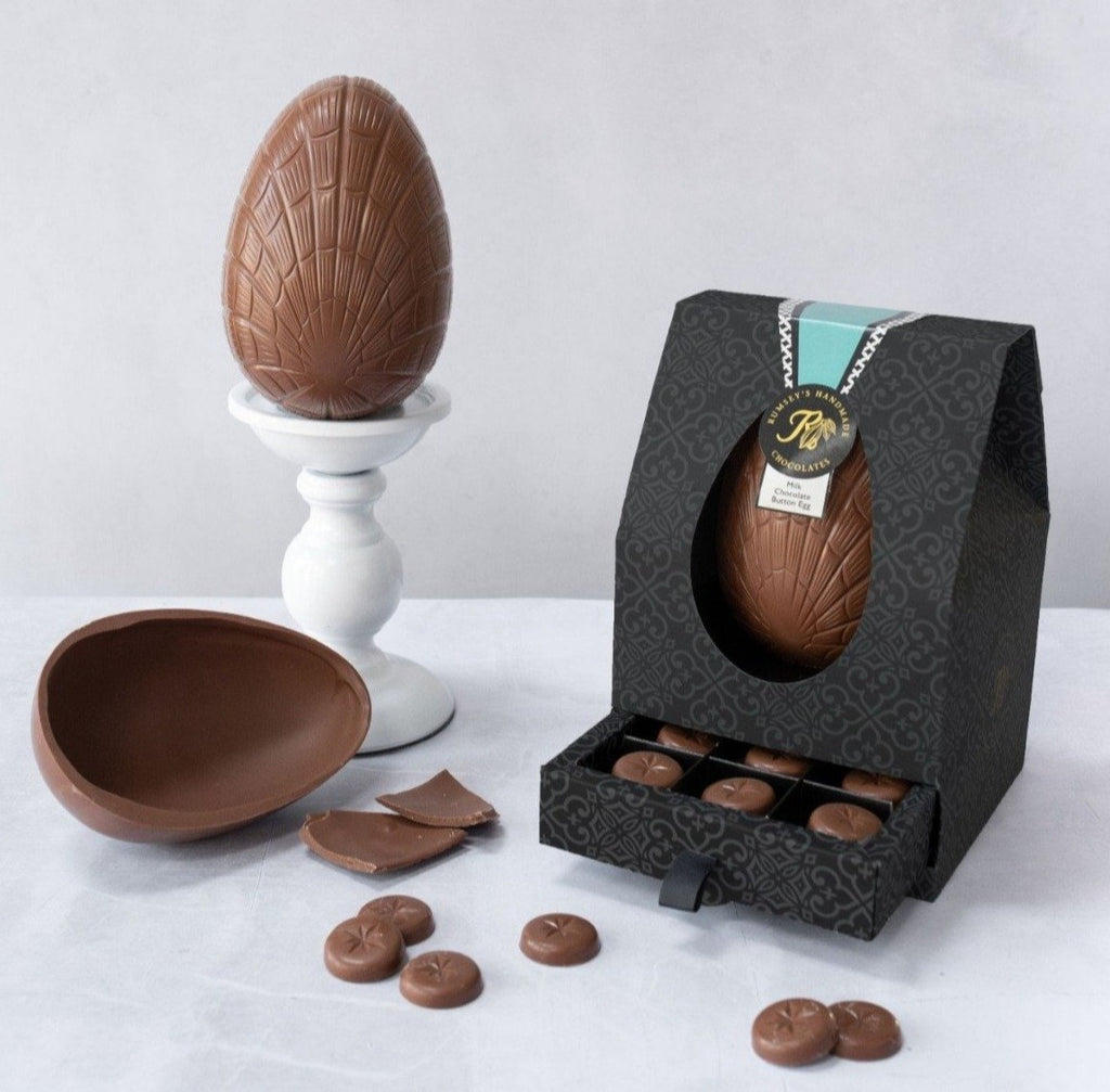 Handmade milk chocolate buttons in a thick chocolate egg