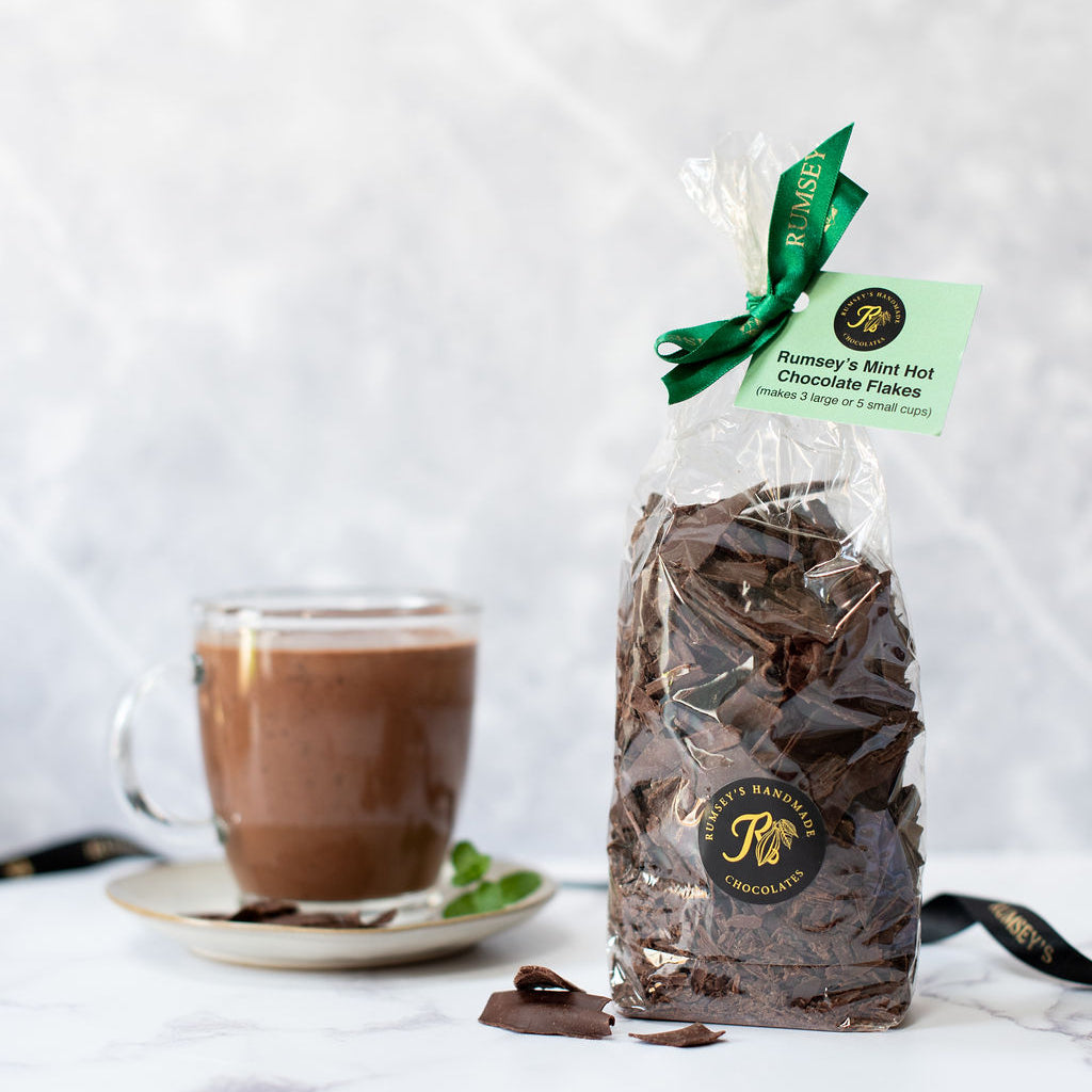 A bag of mint hot chocolate flakes hand wrapped and tied with green ribbon